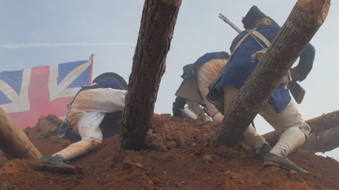 VIRGINIA - OCTOBER 16, 2018 - Reenactment, large-scale, epic American Revolutionary War anniversary recreation - in the midst of battle. Charging Continental Soldiers climb earth fort under explosions