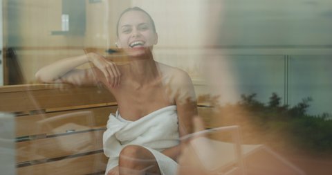 An young happy couple in white bath towels is enjoying their time in sauna in a luxury wellness center