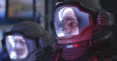 Medium close-up of a young male astronaut experiencing pain during rocket launch