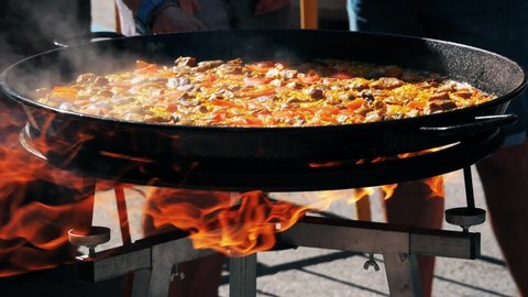 Cooking a tasty paella outdoors during the first paella festival in the village of Cullera, which is located in the community of Valencia, in Spain, Europe