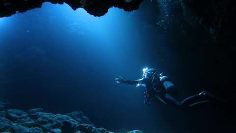 Diver swimming in a submarine cave on Shimojima in Miyakojima city.