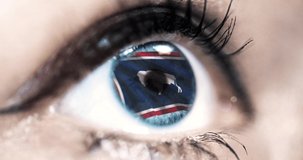 Woman blue eye in close up with the flag of Wyoming state in iris, united states of america with wind motion. video concept