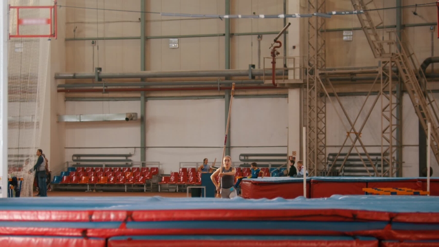 pole vaulting - young sportswoman is running and jumping over the bar