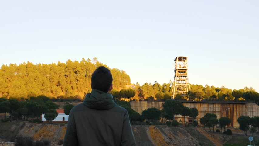 Man walking across the field in the sunset