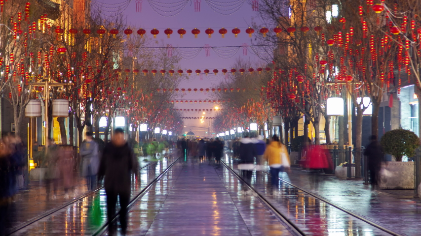 Chinese people walk on Qianmen street in Beijing timelapse zoom out