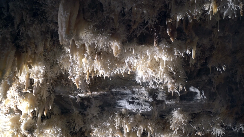 Beautiful giant cave with mysterious light. Stalactites and stalagmites illuminated by beautiful changing light. Giant grotto underground. Underground Kingdom. Journey to the center of the earth.