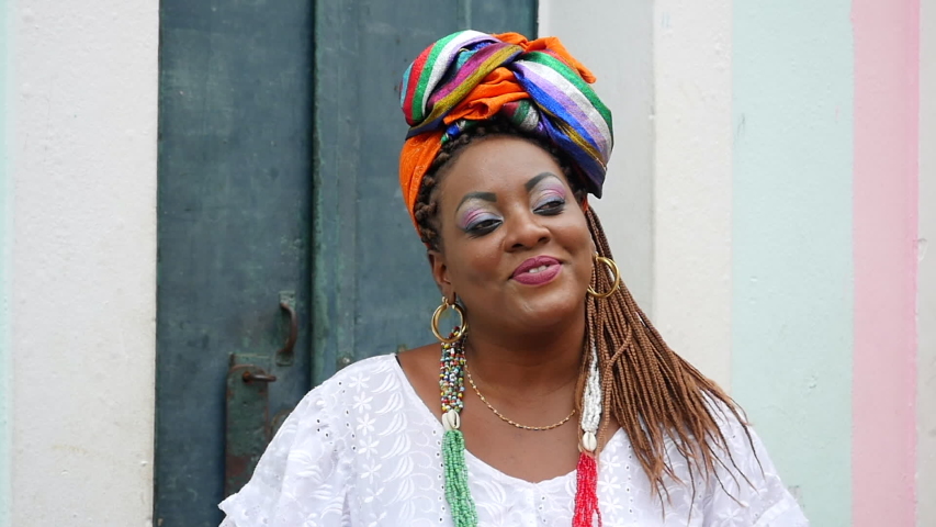 Portrait of a happy Brazilian woman of African descent dressed in traditional Baiana costumes in the Pelourinho district of Salvador da Bahia, Brazil.   Royalty-Free Stock Footage #1041867988