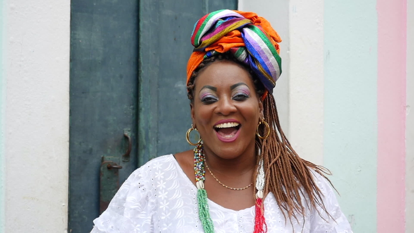 Portrait of a happy Brazilian woman of African descent dressed in traditional Baiana costumes in the Pelourinho district of Salvador da Bahia, Brazil.   | Shutterstock HD Video #1041867988
