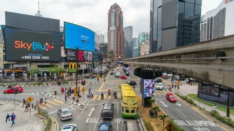 KUALA LUMPUR, MALAYSIA - SEPTEMBER 28, 2019: Time lapse footage of Bukit Bintang landmark, public transportation, pedestrians crossing road, busy traffic and urban life.
