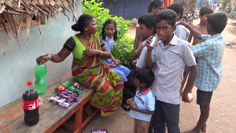 PUDUCHERRY, INDIA - DECEMBER Circa, 2018. Unidentified  Indian families mothers with children drinking eating biscuit in the street of poor village. Dalits, harijans people in south India.  