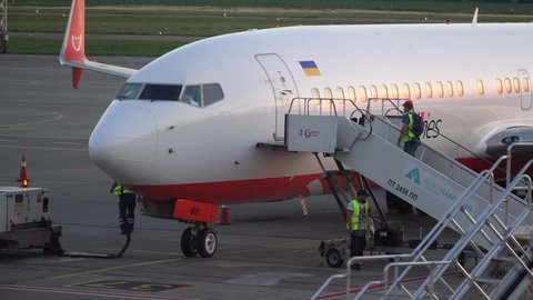 BORISPOL, UKRAINE - JUNE 2019: Airport technician gives permission to open a door aboard airliner for boarding passengers