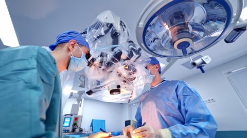 VINNITSA, UKRAINE - August 2019: Operating Room With Surgery In Progress. Medical team performing surgical operation in bright modern operating room