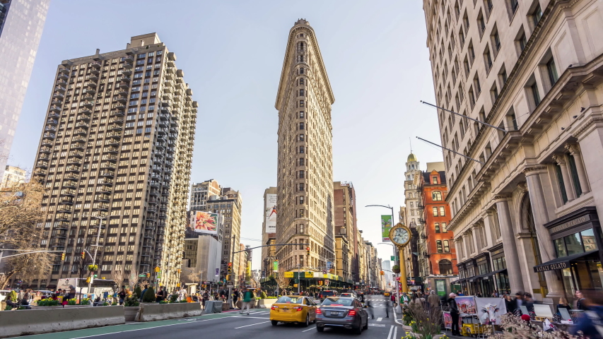 New York City, USA - April 1, 2019: Time-lapse of car traffic, people walking at Flatiron building district, New York City, United state. American city life, travel and transportation concept.
