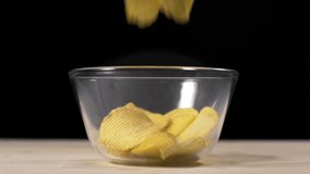 slow motion video of falling groved potato chips