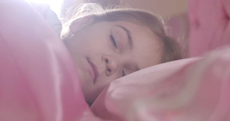 Close-up face of charming Caucasian girl with brown eyes waking up in the morning in pink bed. Portrait of beautiful sleepy teen child. Cinema 4k ProRes HQ. | Shutterstock HD Video #1041904924
