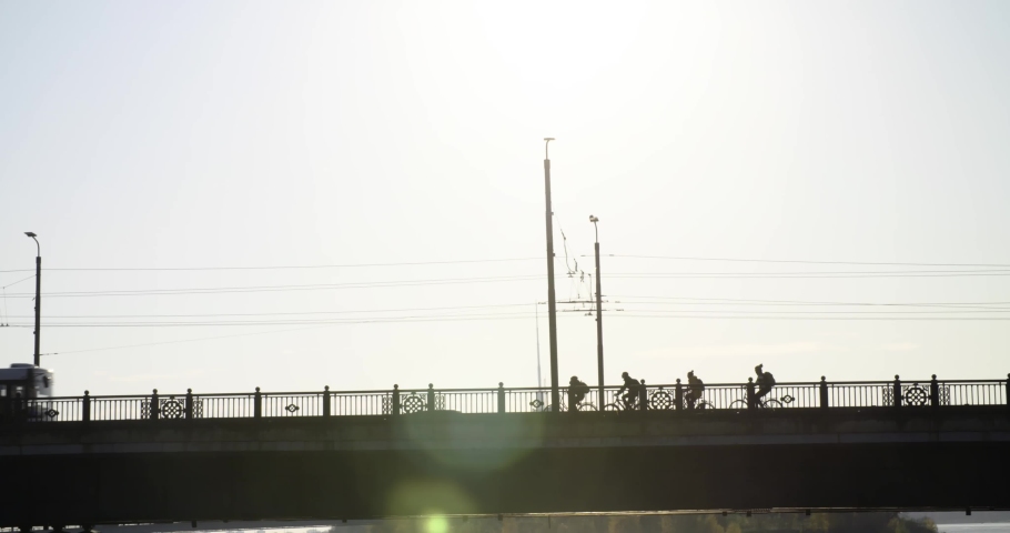 Cycling commuters and electric tram crossing paths in Riga, Latvia