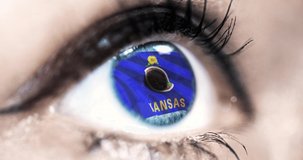 Woman blue eye in close up with the flag of Kansas state in iris, united states of america with wind motion. video concept