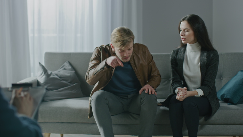 Young Couple on a Counseling Session with Psychotherapist. Back View of Therapist Taking Notes: Angry and Aggressive Boyfriend loses Temper, Starts a Fight, Shouts at His Suffering Girlfriend | Shutterstock HD Video #1041916777