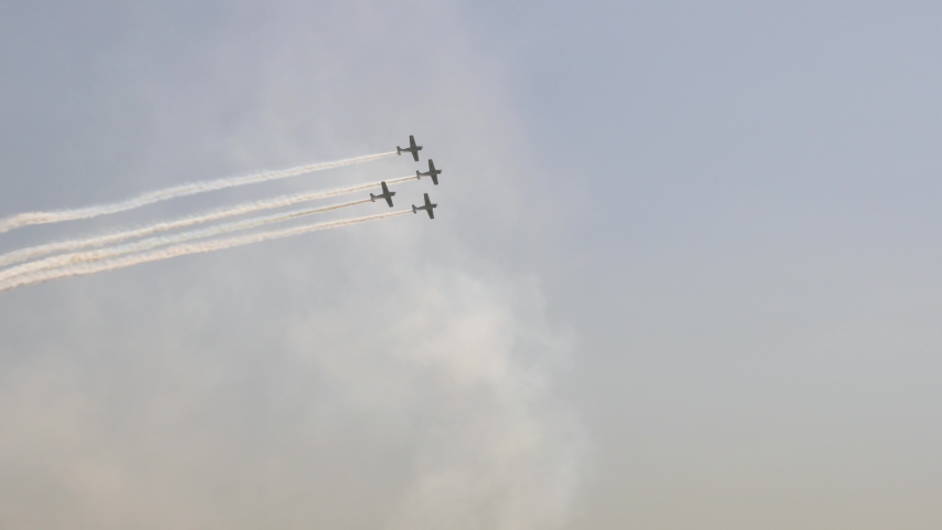 Clear sky, Flying four aircraft Make a turn to Leave white trail in the sky