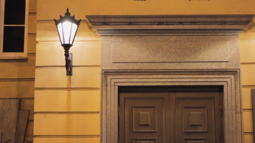 vintage entrance door with a lantern. historic building facade. stone aged