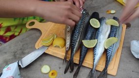 Cooking fish with lemons outdoors closeup