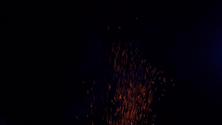 sparks from fire fly up at night in the moonlight 100 FPS Slow Motion