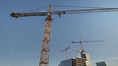 Construction cranes at a construction site in a city.