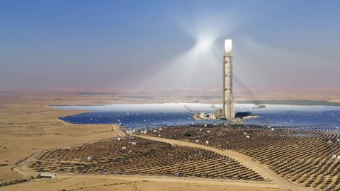Aerial view of a Solar power tower and mirrors that focus the sun's rays upon a collector tower to produce renewable, pollution-free energy.