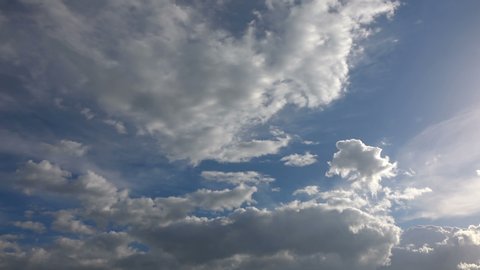 Cumulus rain clouds in motion, timelapse of dramatic blue sky