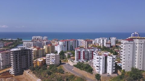 Breathtaking view of summer landscape with the city in Turkey by the sea. Art. Many high buildings and residential houses in front of blue endless sea.