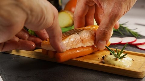 Preparation of grilled salmon steak topped with black pepper and lemon to enhance the flavor of the in a wooden plate And salads and baked potatoes