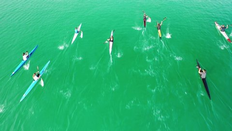 Aerial drone top down video of fit women competing in sport canoe in tropical exotic lake with emerald waters. – Stockvideo