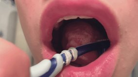 Teenager boy cleaning his teeth. Close up video of young man clean dirty tooth.