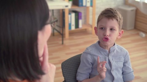 Close-up of a speech therapist deals with a little boy