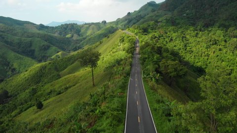4k Aerial drone shot top view sky road on top of mountain, across mountain, Sunny day, green forest, abundant jungle, cloudy sky mountain hill, travel destination, tropical weather, Nan, Thailand. 