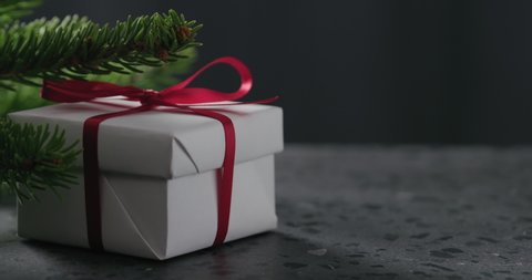 Slow motion man hand put merry christmas card next to gift box