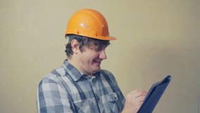 cheerful middle aged man in a construction helmet holds a folder with documents.video portrait of a builder at work