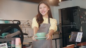 Portrait young Asian lady barista waitress holding coffee cup feeling happy at urban cafe. Asia small business owner girl in apron relax toothy smile looking to camera stand at counter in coffee shop. - Powered by Shutterstock - Get 15% off with code: PIKWIZARD15