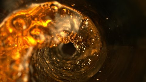 Super Slow Motion Abstract Shot of Pouring Golden Liquid in Glass Bottle at 1000 fps.