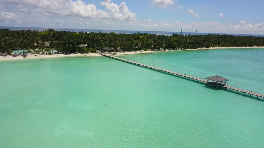 Aerial view to bungalow behing palms In Maldives Island in Indian ocean 4K