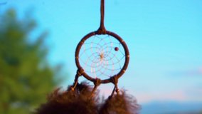 Slow Motion View Of Dream Catcher Hanging From Rear view Mirror Inside Car. Dream-catcher waving in the wind in the sunset sunlight. View of the road and sunset ligh. Travel by car. Road trip concept. - Powered by Shutterstock - Get 15% off with code: PIKWIZARD15