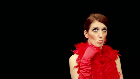 A pretty lady, wearing a showy red dress with a feather boa, annoyed by someone near her (maybe having a bad pickup experience). Front medium shot over a black background.
