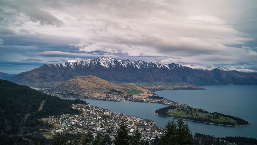 Clouds moving over Lake Wakatipu with the town of Queenstown in the valley below and The Remarkables mountains range in the distance. Time lapse captured in beautiful New Zealand’s South Island.