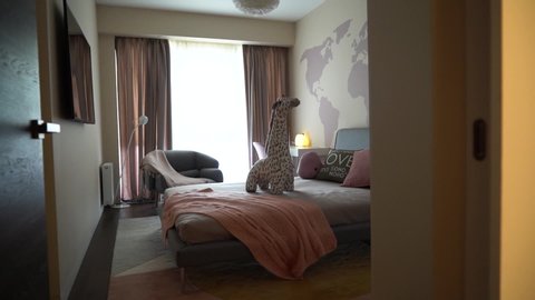 Moscow, Russia - 25 11 2018: Children's bedroom with a world map on the wall and a toy giraffe on the bed with pillows