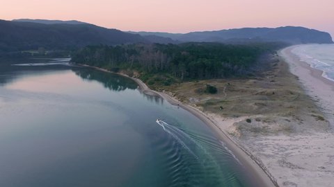 Aerial: Flying Over Opoutere Beach and estuary at sunset. Coromandel Peninsula, New Zealand 