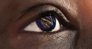 Woman black eye in close up with the flag of Mebraska state in iris, united states of america with wind motion. video concept