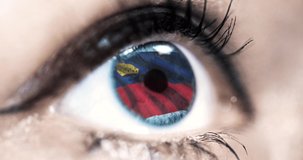 woman blue eye in close up with the flag of Liechtenstein in iris with wind motion. video concept