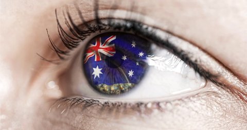 woman green eye in close up with the flag Australia a in iris with wind motion. video concept