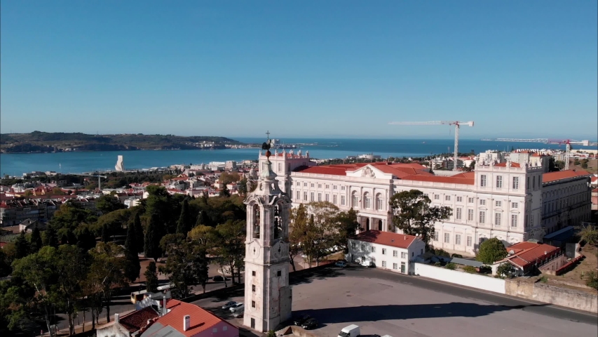 Aerial parallax view Palácio da Ajuda royal palace in Lisbon with bell tower on foreground and cityscape with river on background, Portugal historic touristic attracton
