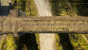 Aerial view. Old railway bridge and a car passing under it. Car driving. Ukrainian Carpathian. Autumn in Ukraine